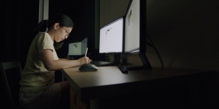 亚洲女商人Candid晚上在家庭办公室用平板电脑写作。