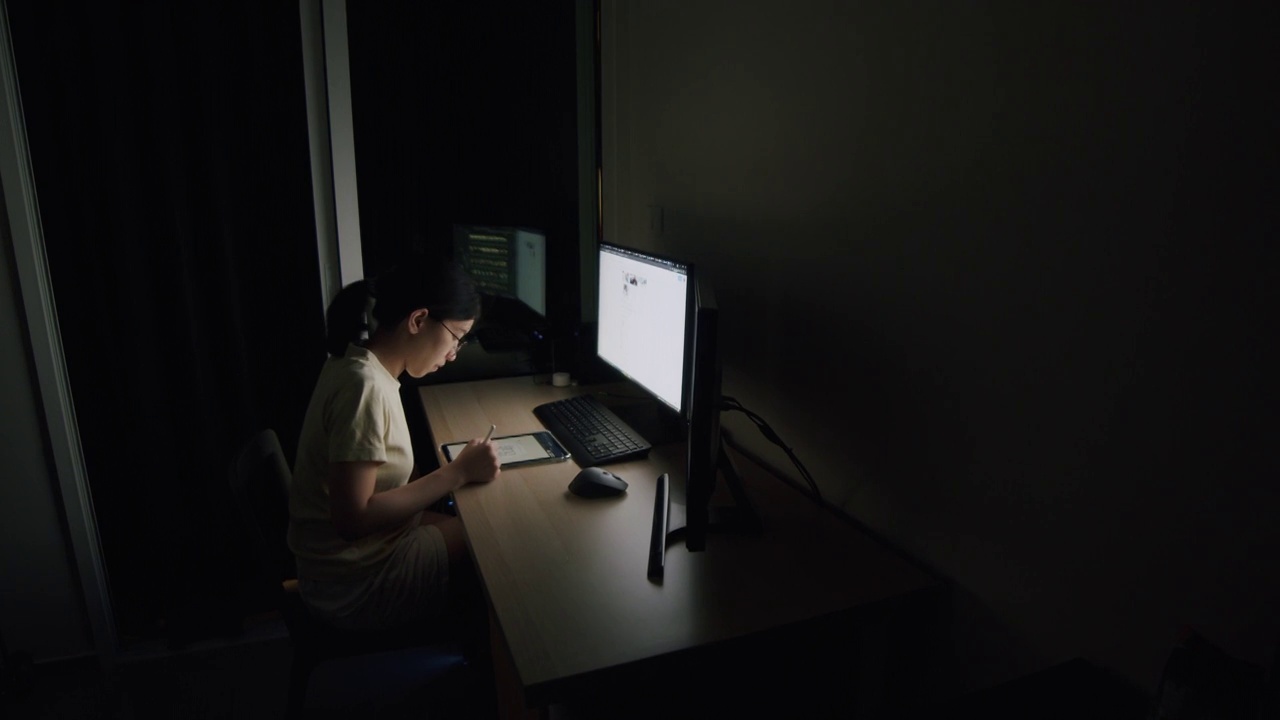 亚洲女商人Candid晚上在家庭办公室用平板电脑写文章，滚动新闻推送，搜索在线信息数据，为她的工作计划。