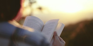 女人在户外看书放松，在大自然伴着夕阳