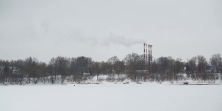 在一个寒冷的日子里，工厂里的烟斗在城市中心抽烟。环境污染。类