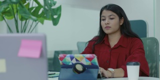 亚洲女性员工使用平板电脑共同工作。