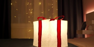 在夜晚，礼品盒灯的灯光照亮了装饰过的房间。生日、圣诞节、新年喜庆彩灯。