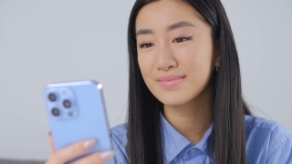 美丽的亚洲女孩打字短信在手机上。可爱的年轻越南女子使用现代智能手机进行在线交流和网络。来自亚洲的漂亮女性使用社交媒体应用程序视频素材模板下载