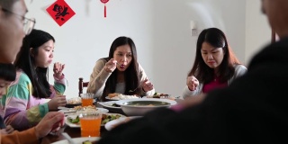 三代亚洲华人家庭在家里一起吃团圆饭