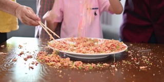 快乐微笑的多代亚裔华人家庭在中国新年庆祝活动中抛生鱼菜肴怡生
