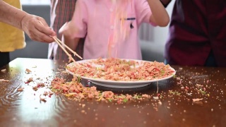 快乐微笑的多代亚裔华人家庭在中国新年庆祝活动中抛生鱼菜肴怡生视频素材模板下载