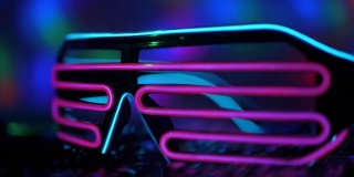 来自未来的霓虹灯眼镜躺在迪斯科舞厅的亮片上