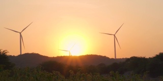 在印度古吉拉特邦的万卡纳，夕阳下的风车剪影。绿色能源的背景。夕阳下风电场的剪影。清洁能源的背景