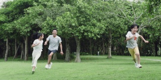 亚裔父亲和孩子们在公园里嬉戏追逐嬉笑