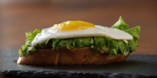 一个美味的新鲜三明治的特写，烤面包，绿色沙拉和鸡蛋
