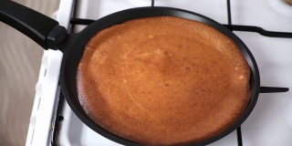 可丽饼是在炉子上煎制的。煎饼烤的过程。俄罗斯的小薄饼。
