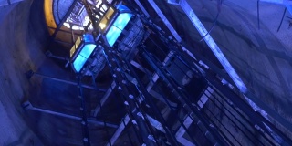通过深井上下的人乘坐的电梯被蓝色的94p2灯照亮