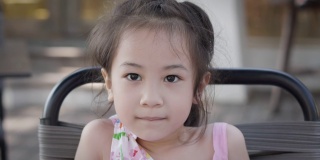 近距离的美丽和可爱的脸与闪烁的眼睛5岁的亚洲女孩谁是看着相机的自信和幸福表达积极的态度和坚定的情绪。