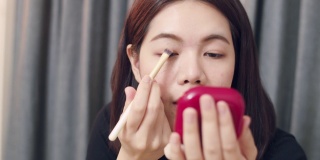 亚洲女性美妆博主影响力人物每日化妆教程在相机上展示，并在社交媒体上直播。