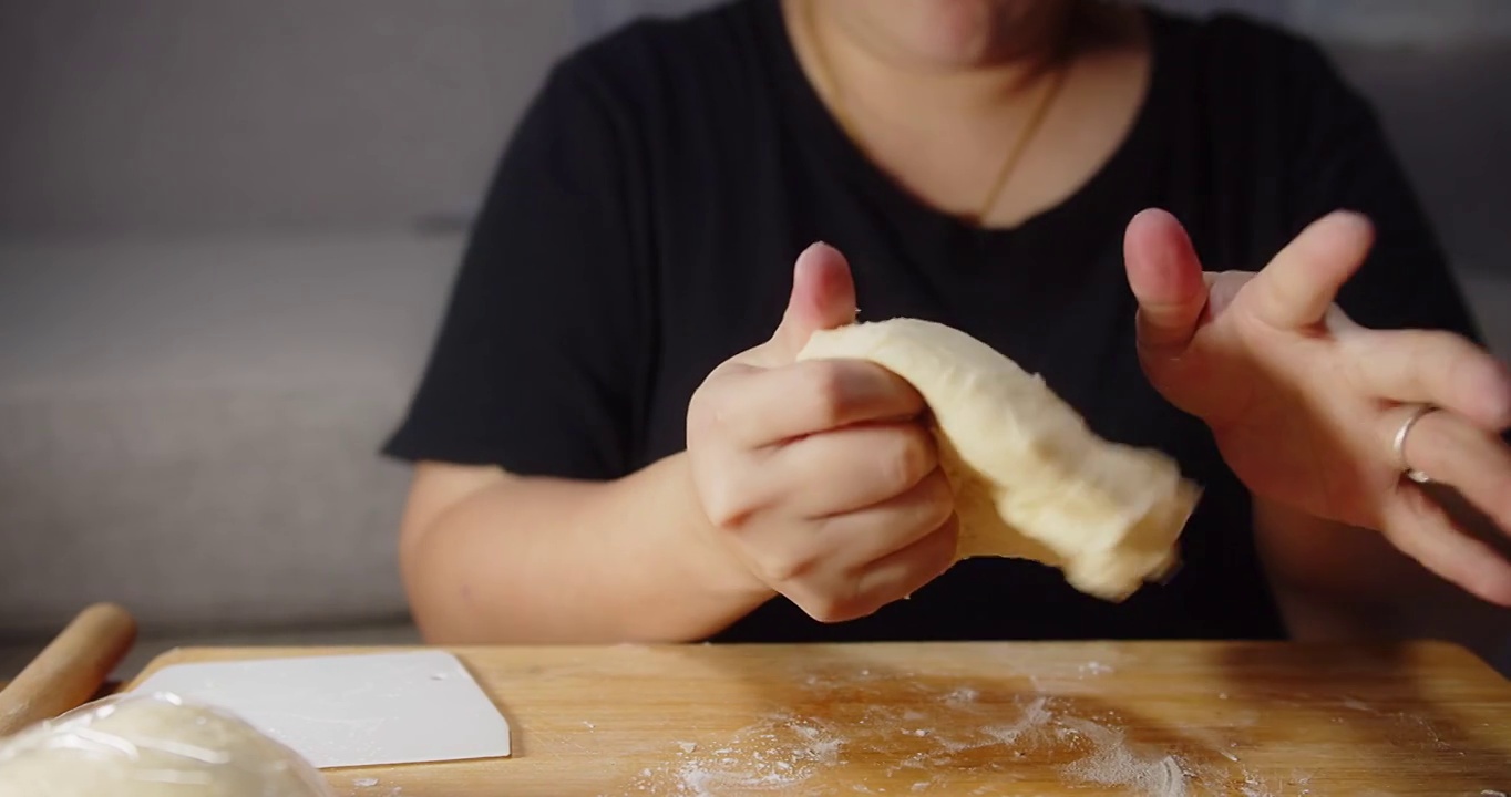 近的亚洲妇女糕点面包房厨师准备捏软面团用传统食谱自制面包的手