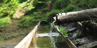 木制饮用自然喷泉。清凉的山水，秋林溪流。地球生态