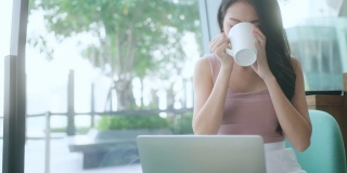 女性的手年轻的亚洲女性用户工人使用笔记本电脑打字笔记本电脑键盘坐在咖啡馆的桌子上工作与笔记本电脑软件应用技术的概念