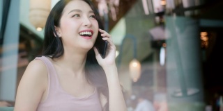 有吸引力的亚洲女性成年成熟女性休闲放松手使用智能手机友好的交谈生活方式使用公共互联网连接移动打电话在咖啡馆咖啡店