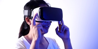 年轻女子在Metaverse体验VR时使用虚拟现实耳机触摸空气。VR(虚拟现实)，技术，视频游戏和元世界概念。