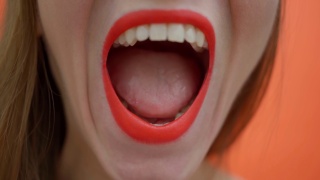 嘴唇上涂着红色口红的女人在大声尖叫。红唇配白视频素材模板下载