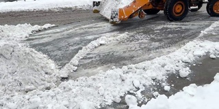 挖掘机，一辆汽车在清理城市街道上的积雪