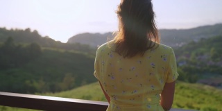 山间现代生态酒店的观景台，女人在享受夏日美景
