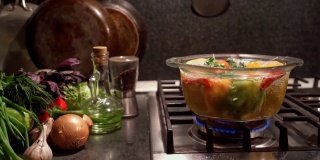 在烧开的水里煮填好的辣椒，放在炉子上一个透明的平底锅里，多利拍