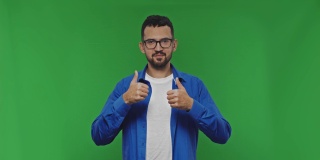 一个微笑的年轻人的肖像，显示两个拇指向上的手势。绿色屏幕上是演播室里的大胡子。