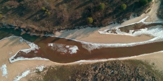 无人机拍摄的冬季小河流上空飞行的镜头。