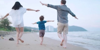 幸福的一家人在沙滩上奔跑