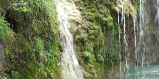 剪裁稳定的镜头，瀑布从长满青苔的悬崖上倾泻而下