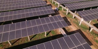 工程师和技术员的鸟瞰图，检查太阳能电池板农场，电力，太阳能产生的清洁能源