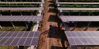 工程师和技术员的鸟瞰图，检查太阳能电池板农场，电力，清洁能源产生的太阳，后视图