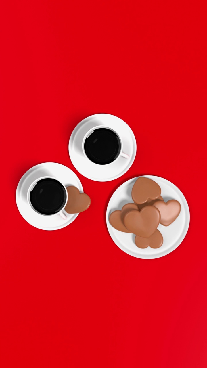 心形饼干和两个咖啡杯在红色背景下4K分辨率垂直视频