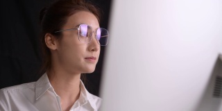 年轻的亚洲女性自由职业者在家里用电脑工作。有吸引力的女商人在线学习，使用计算机软件，网上冲浪信息或在网上商店购物
