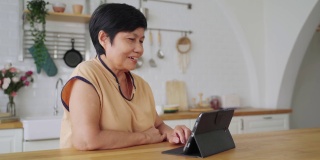 亚洲资深女性使用数码平板电脑进行视频通话