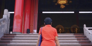 亚洲大妈在寺庙拜佛。