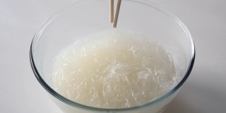 用筷子在热水中搅拌并漂洗玻璃纸面