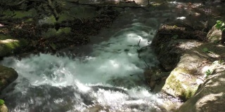 近距离拍摄，稳定的镜头，水从河流的岩石上倾泻而下