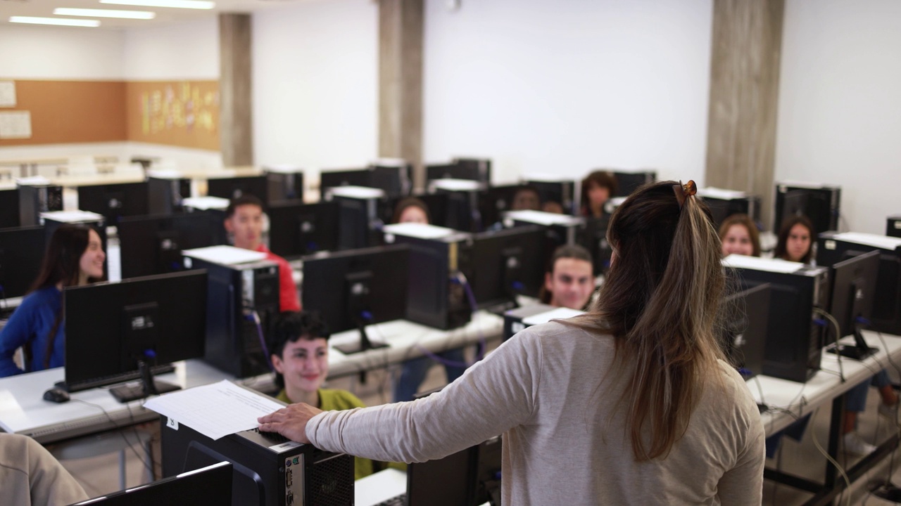 在大学计算机教室里与多种族学生合作的成熟教师