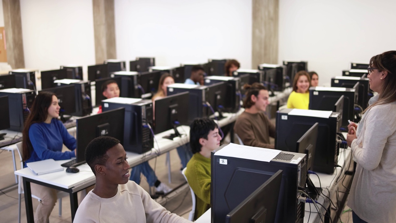在大学计算机室内与多种族学生合作的成熟教师