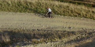 山地自行车骑无人机观看岩石草地路径温暖阳光灿烂的夏日假期
