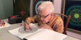亚裔中国老年妇女在家里用马克笔涂色