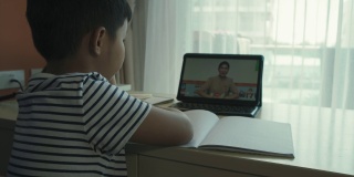 一个亚洲男孩在家参加在线课程。