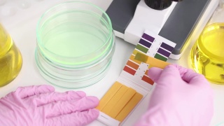 科学家化学家用石蕊试纸在培养皿中测试洗涤剂的酸度，特写4k电影慢动作视频素材模板下载