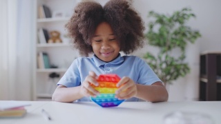 非裔美国女孩玩着烦躁玩具，按下按钮，缓解压力视频素材模板下载