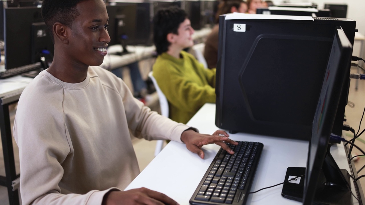 年轻的多种族学生在大学课堂上使用电脑
