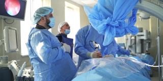 外科医生在手术室工作。一群外科医生带着手术设备在手术室里。