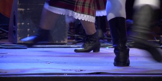在这一场景中，男孩和女孩穿着民族服装跳舞，脚穿靴子，靴子随着音乐的节奏移动