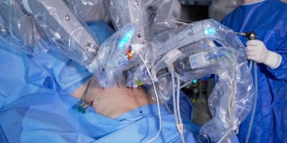 未来外科手术设备操作病人。手术过程中机械臂移动缓慢。站在手术台后面的外科医生。